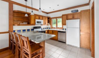 A Lake George lodging with a kitchen featuring wooden cabinets and counter tops.