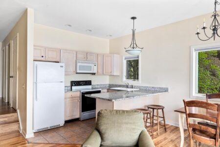 A kitchen with a table and chairs and a refrigerator in one of the best hotels in Lake George.