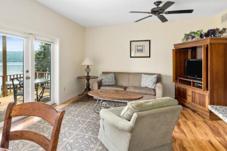 A living room with a balcony overlooking Lake George.