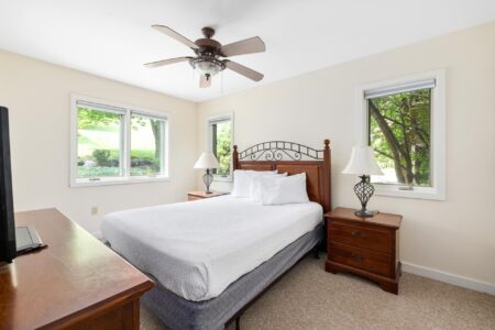 Lake George lodging with a bed and a ceiling fan.