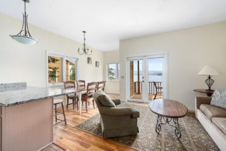 A Lake George resort featuring a living room and kitchen area with a view of the water.