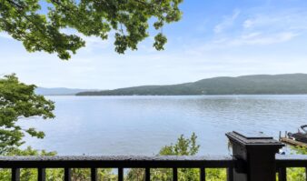 Best hotels in Lake George with a view of the lake and mountains from a deck.