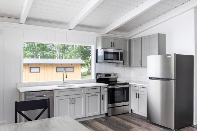 A Lake George resort with a kitchen featuring stainless steel appliances and white cabinets.
