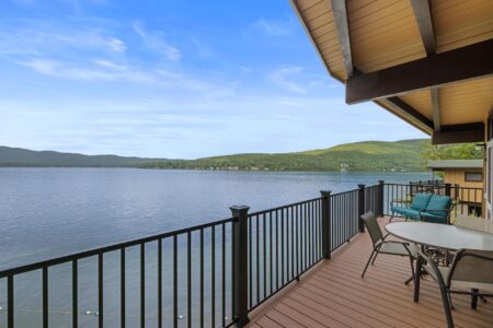 A lakeside balcony with stunning mountain views at Lake George hotels like Erlowest is the perfect setting for a Lake George vacation.