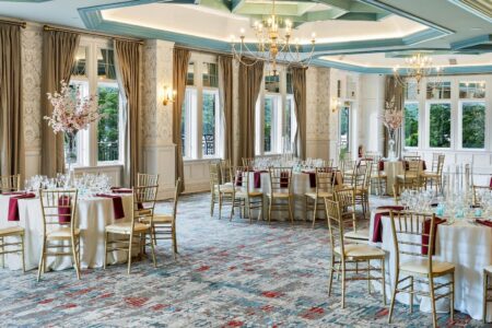 A ballroom at Erlowest, one of the best hotels in Lake George, with tables and chairs set up for a wedding reception.