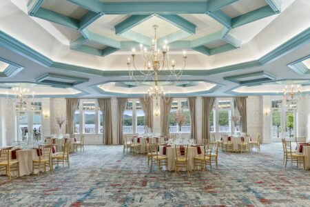 A grand ballroom adorned with majestic chandeliers and serene blue ceilings at Erlowest, one of the best Lake George hotels.