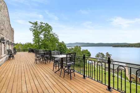 Lake George lodging with a deck overlooking the lake and furnished with tables and chairs.