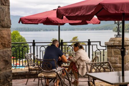 A couple at a Lake George resort, Erlowest, enjoys a scenic view of the lake from their table.