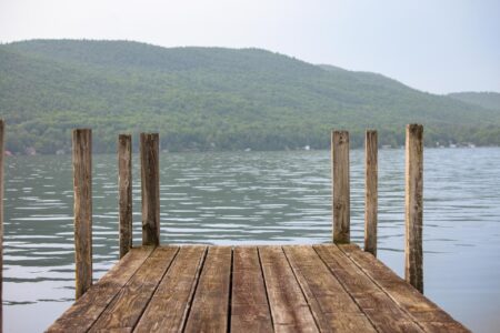 A wooden dock on Lake George with mountains in the background.