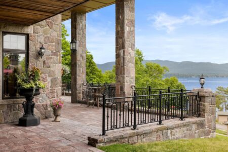 A picturesque stone patio offering incredible views of Lake George and the surrounding mountains, perfect for a memorable Lake George vacation.
