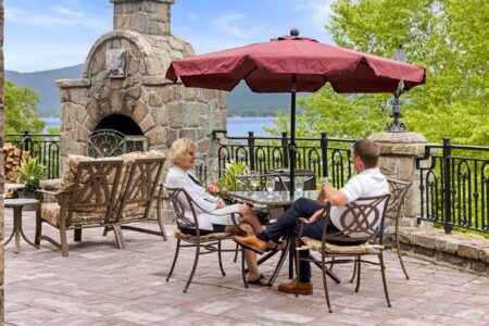 A couple enjoys a romantic meal on a lakefront patio at a Lake George resort.