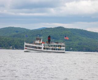 A boat on Lake George with mountains in the background, near Erlowest.