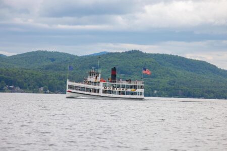 A boat on Lake George with mountains in the background, near Erlowest