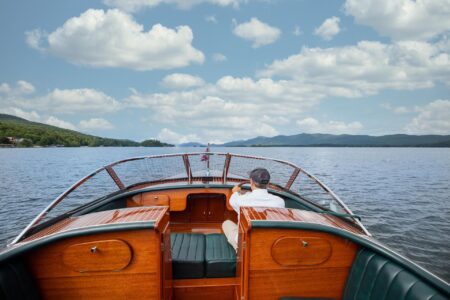 A person is onboard a boat near Lake George lodging