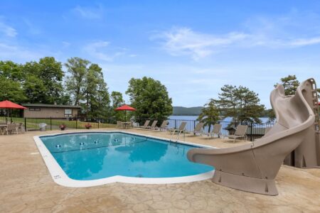 Lake George lodging with a swimming pool equipped with a slide and lounge chairs provided at Erlowest hotels.