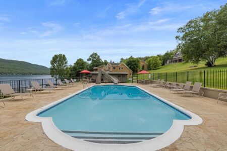 Lake George lodging with a pool and lounge chairs offering breathtaking views of Lake George.