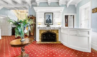 Lake George lodging with a cozy living room featuring a fireplace and red carpet.