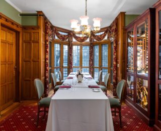 A Lake George hotel dining room with a table and chairs.