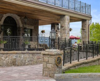 A Lake George vacation resort featuring a stone house with wrought iron railings.