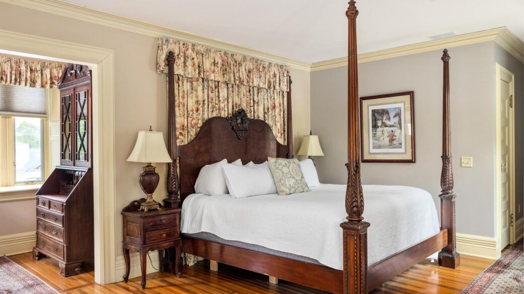 Lake George lodging with a four-poster bed and a dresser.