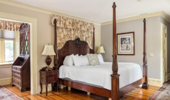 Lake George lodging with a four-poster bed and a dresser.