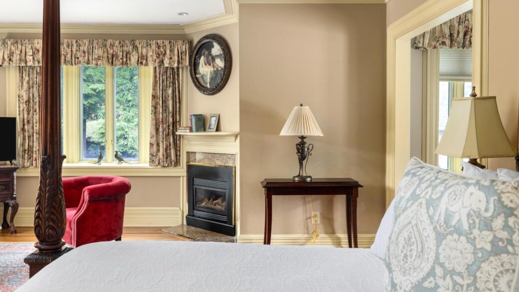 Lake George lodging: A cozy bed in a room with a fireplace.