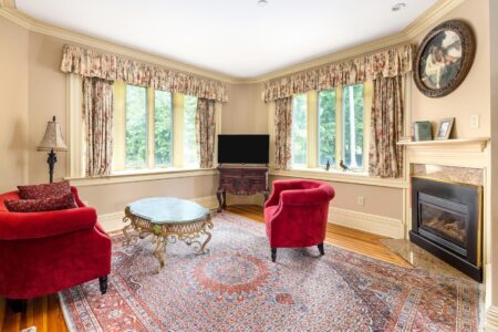 Lake George lodging with a cozy living room featuring red chairs and a fireplace.