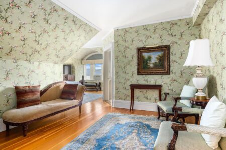 A Lake George resort with a living room featuring floral wallpaper.