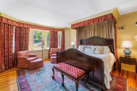 Lake George lodging with an ornate bed and red curtains.