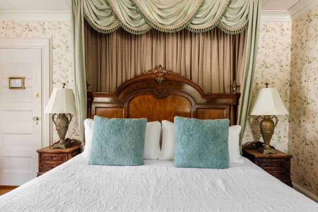 A pristine canopy bed sits in a beautifully decorated room at Erlowest, a luxury Lake George Hotel.
