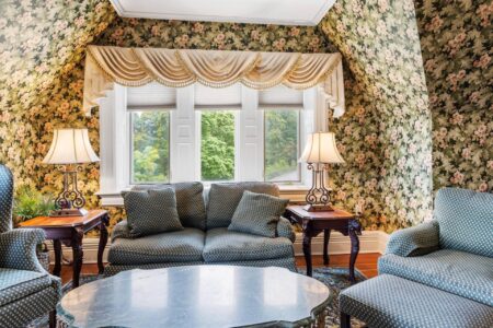 A living room with floral wallpaper located in Erlowest, one of the Lake George hotels perfect for a tranquil Lake George vacation