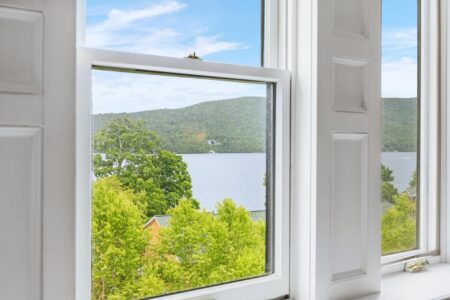 A picturesque lake view from a white window at Erlowest - one of the best hotels in Lake George lodging