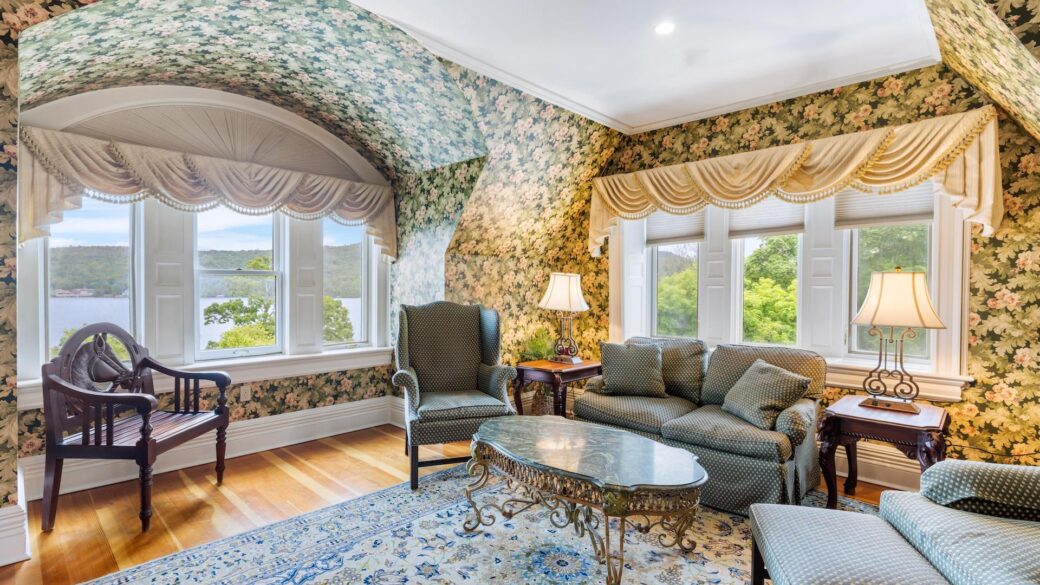 A Lake George resort living room with floral wallpaper and a window.