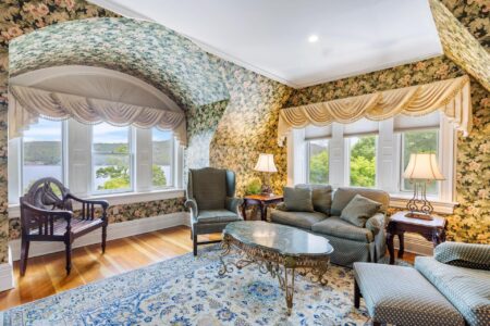 A Lake George resort living room with floral wallpaper and a window