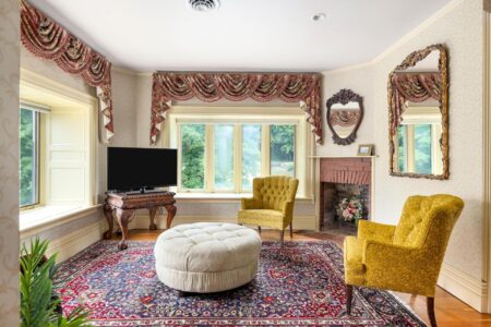 A Lake George resort living room adorned with an ornate rug and yellow chairs