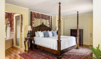 An ornate bedroom with a four poster bed at Lake George lodging.