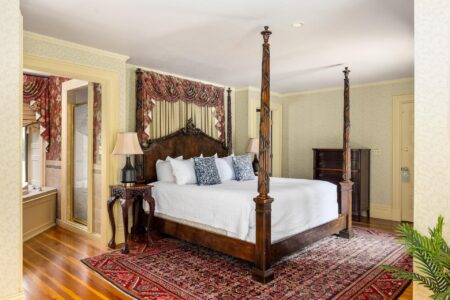 An ornate bedroom with a four poster bed at Lake George lodging