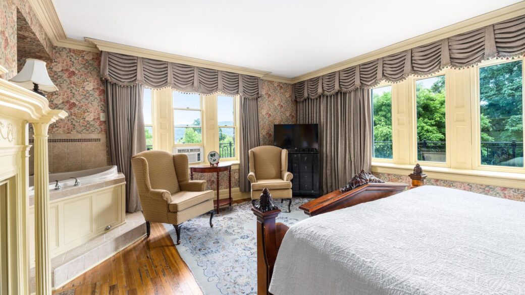 Lake George lodging: A bedroom in a Lake George resort with a bed and a fireplace.