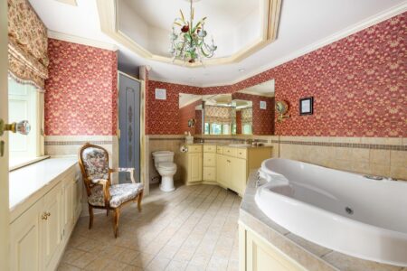 A Lake George resort bathroom with red wallpaper and a bathtub.