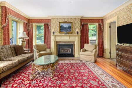 An ornate living room in a Lake George resort with a fireplace and a TV.