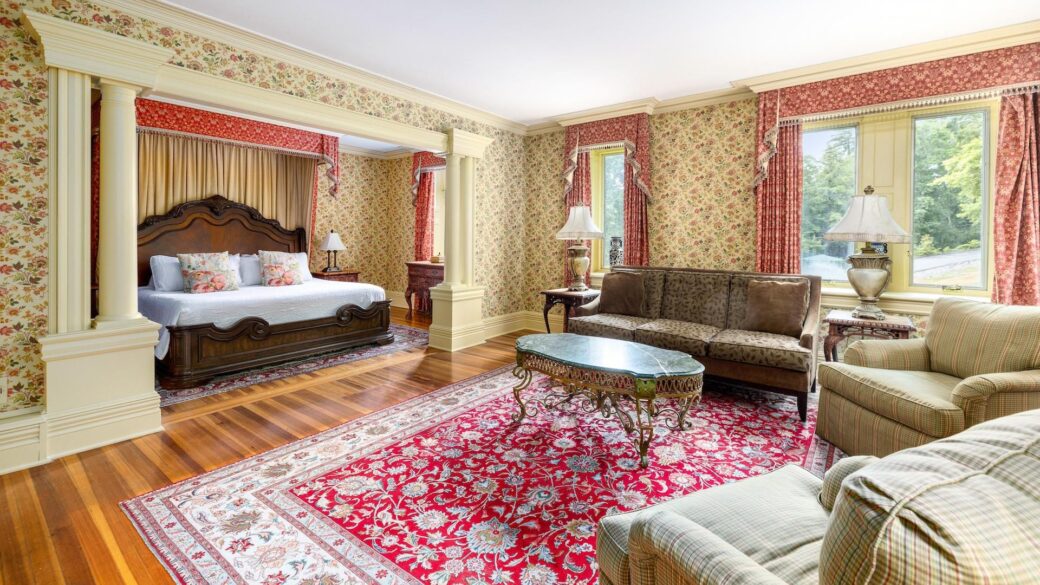 An ornately decorated bedroom at Erlowest, a Lake George lodging, featuring a bed and couch.