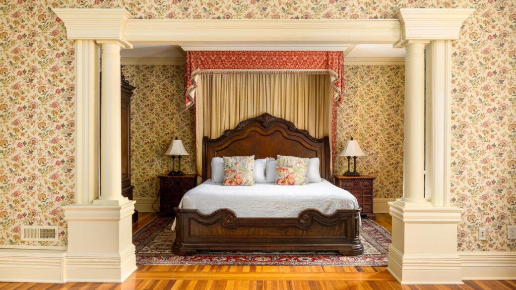 A bedroom with floral wallpaper and a bed in Erlowest, one of the best hotels in Lake George lodging.