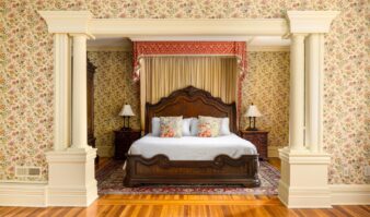 A bedroom with floral wallpaper and a bed in Erlowest, one of the best hotels in Lake George lodging.