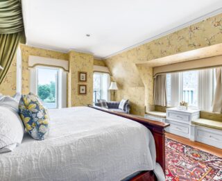 A bedroom with floral wallpaper and a bed located in Erlowest, one of the best hotels in Lake George.