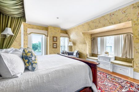A bedroom with floral wallpaper and a bed located in Erlowest, one of the best hotels in Lake George.