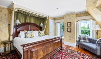 An ornate bedroom in Erlowest, one of the Lake George resorts, featuring a luxurious bed and rug.