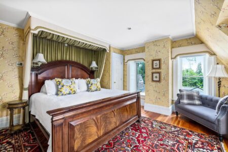 An ornate bed and rug in a Lake George resort bedroom.