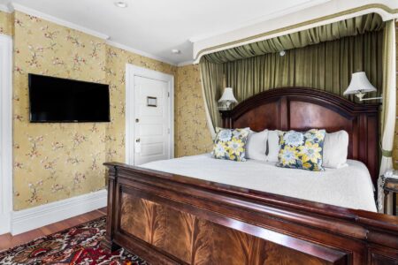Lake George lodging with a floral wallpapered bedroom and a TV.