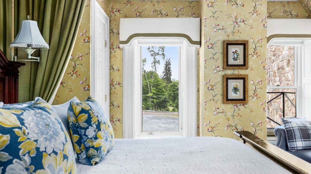 A bed in one of the best hotels in Lake George, with floral wallpaper.