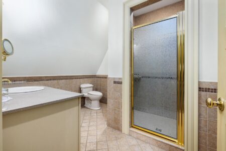 A Lake George vacation rental featuring a bathroom with a shower and toilet.